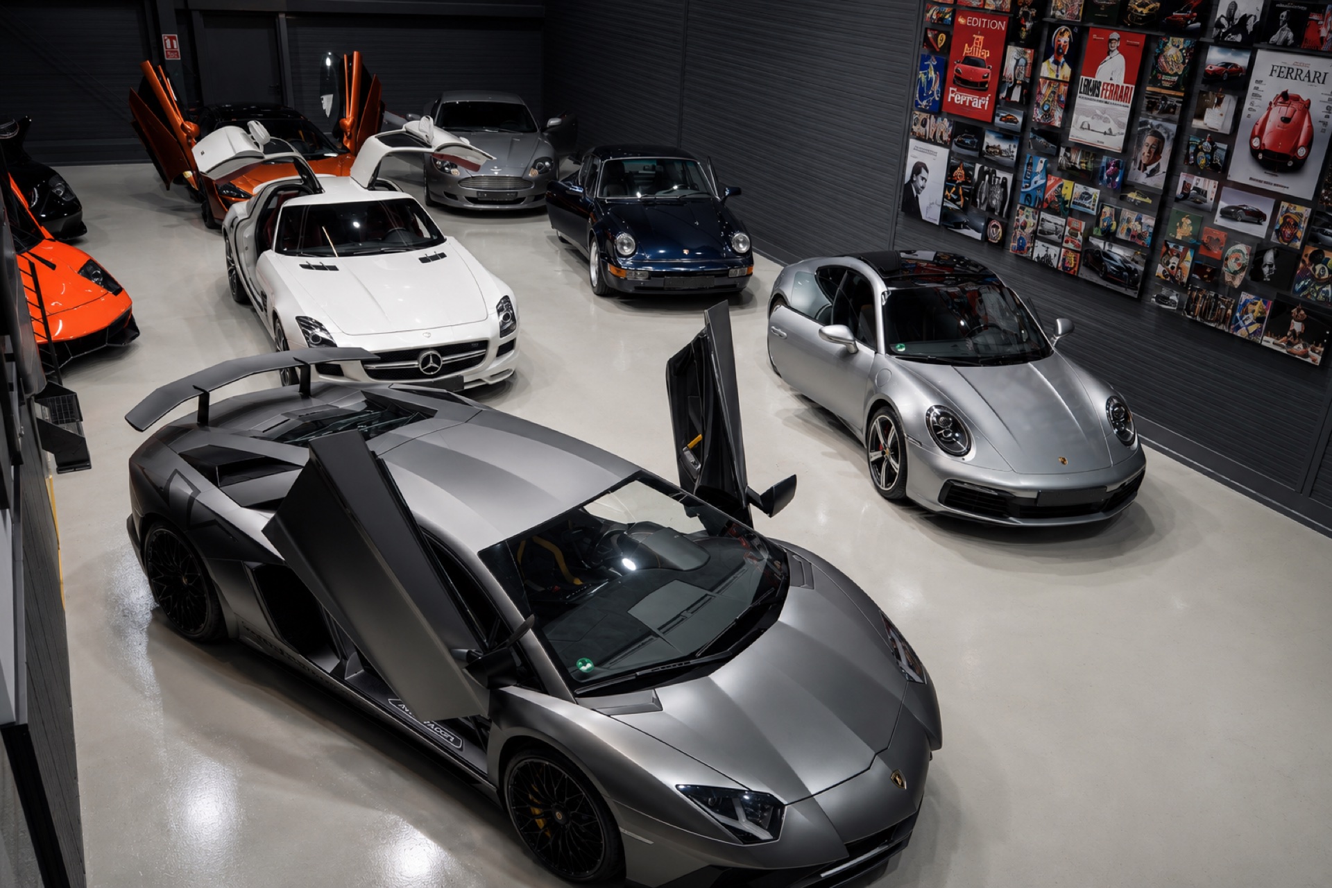 McLaren mit Flügeltür, Porsche und Aston Martin im Showroom